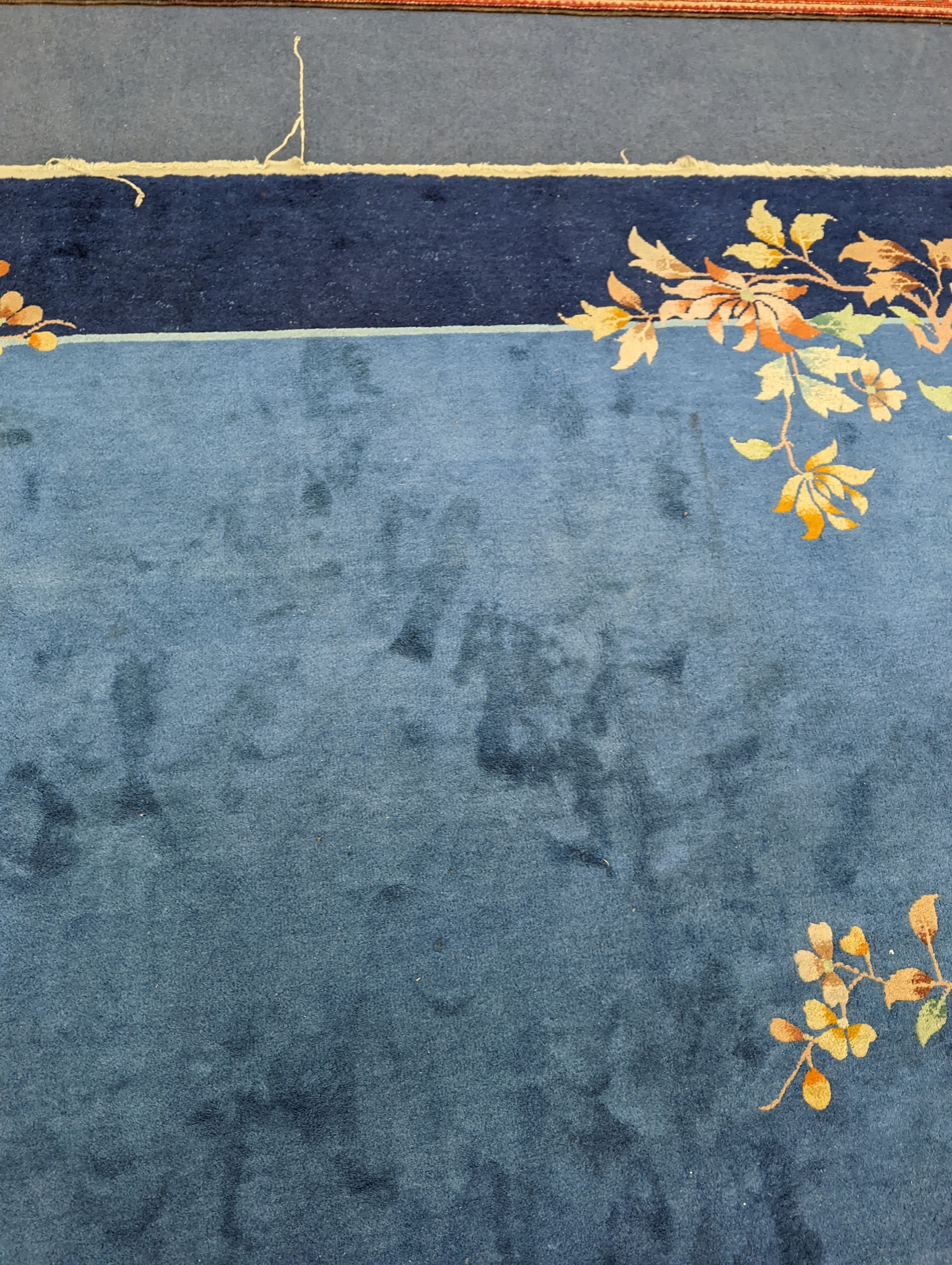 An early 20th century Art Deco Chinese blue ground floral carpet, 400 x 310cm